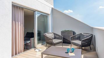Suite junior, terraza | Edredones de plumas, minibar, caja fuerte y escritorio