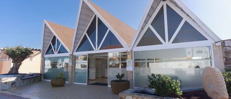 A modern building with a triangular roof and large windows.