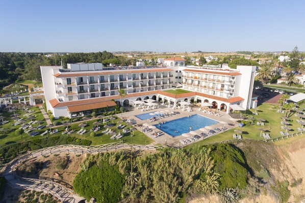 A large hotel with multiple balconies, a swimming pool, and a landscaped garden. - Hipotels Hotel Flamenco Conil (Conil de la Frontera)