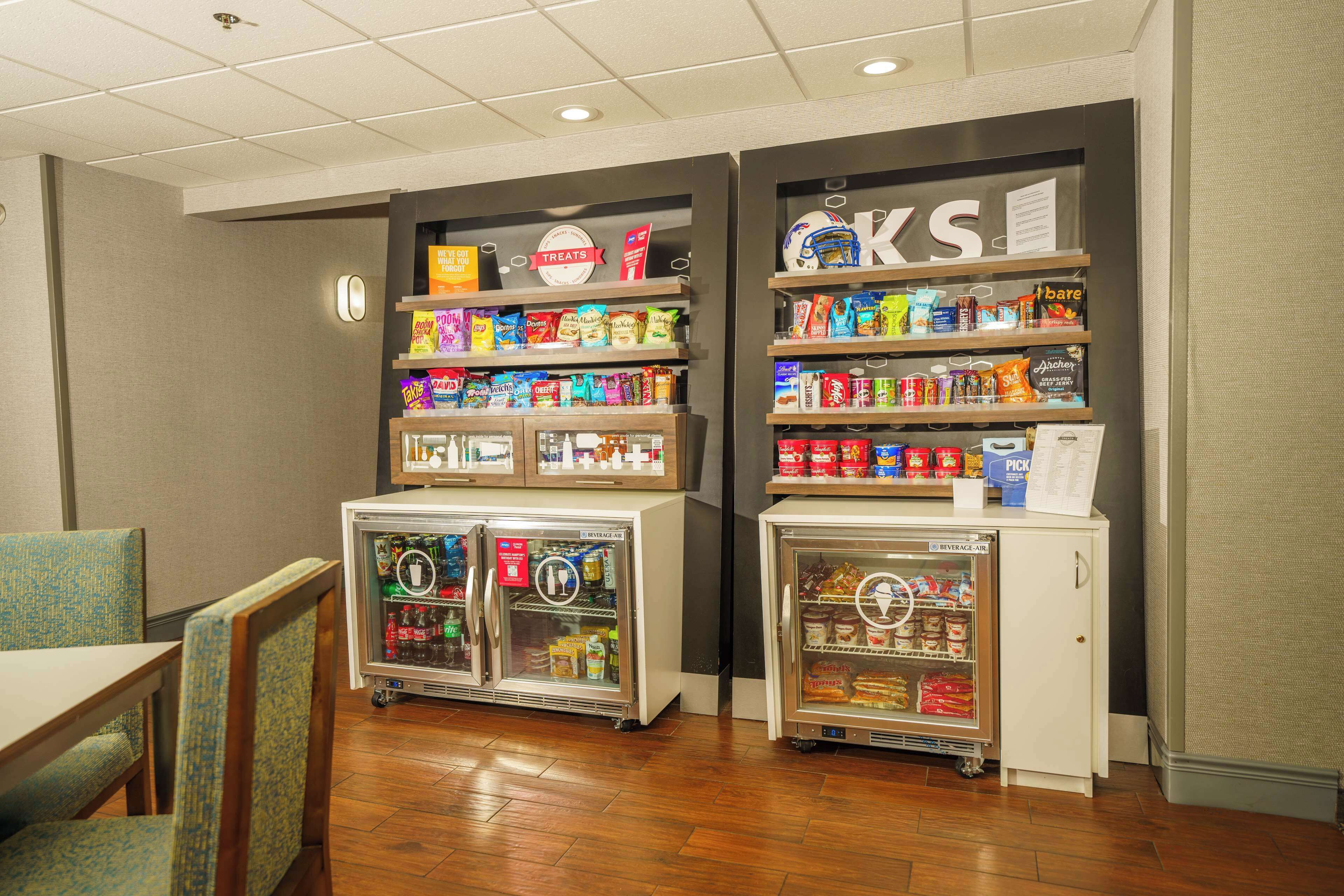 A snack bar with refrigerated display cases and shelves stocked with various snacks and beverages.
