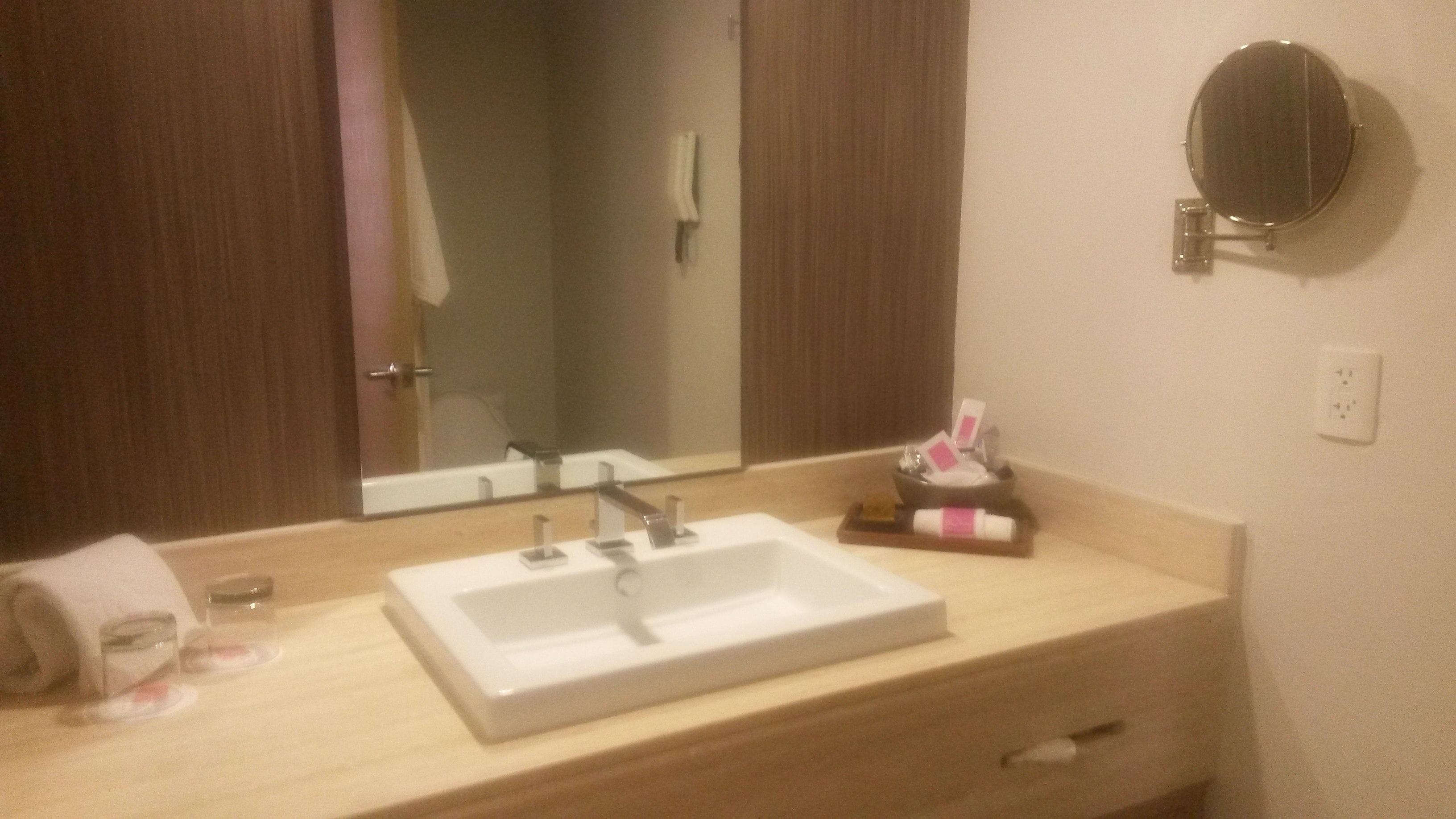 A bathroom with a white sink, a mirror, and a towel rack.