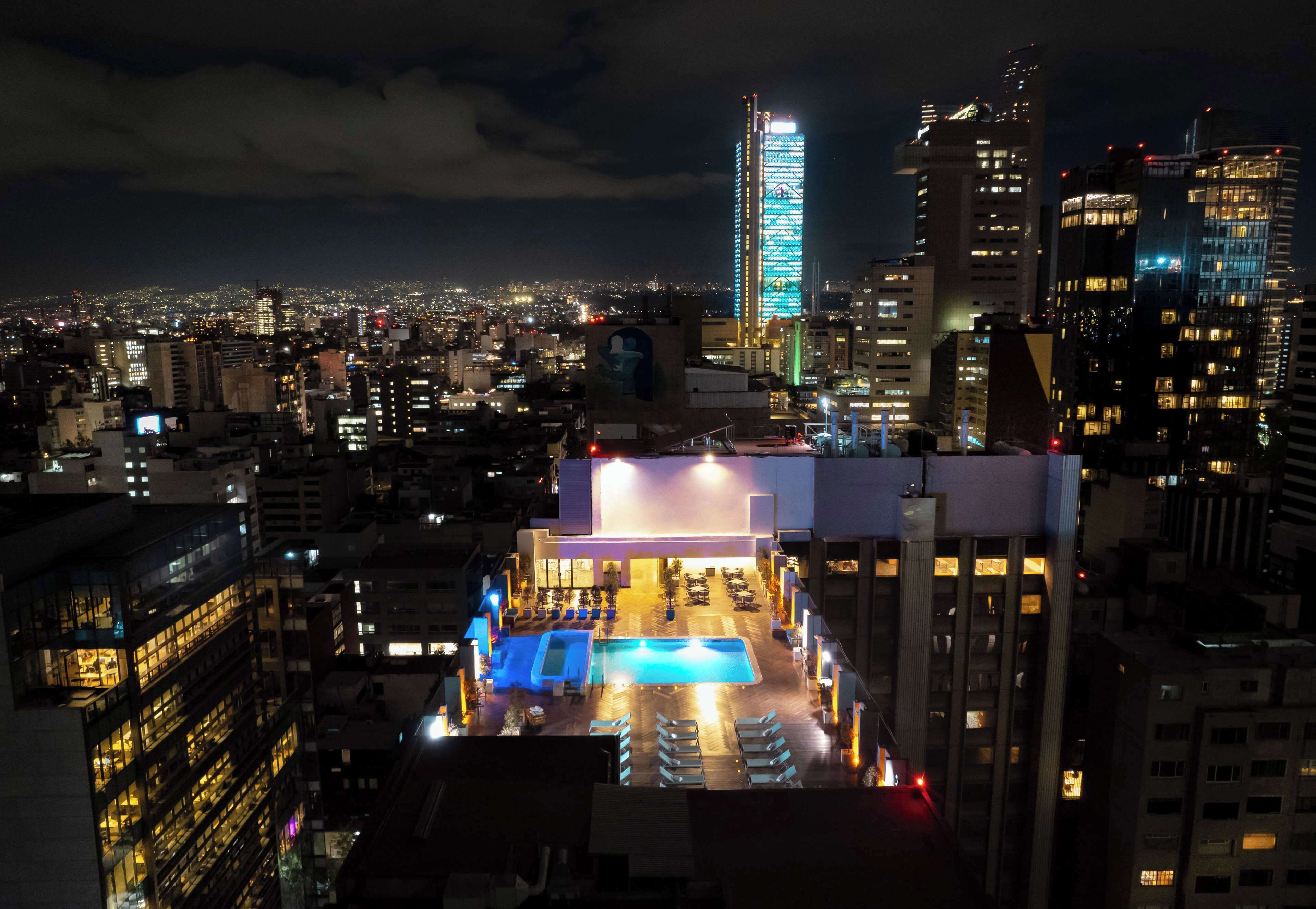 A hotel with a rooftop pool and a cityscape view.