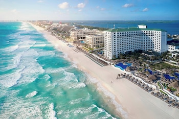 A resort with a large pool area, a beach, and a view of the ocean. at JW Marriott Cancun Resort & Spa