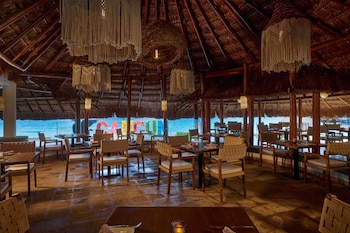 A corridor with brick walls, large columns, and a ceiling with wooden beams. at JW Marriott Cancun Resort & Spa