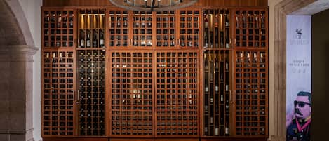 A wine cellar with wooden cabinets and a chandelier.