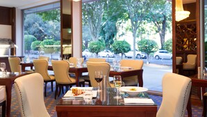 Un restaurante con mesas dispuestas para comer, sillas y vistas a la calle.