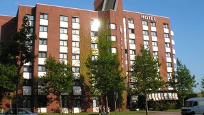 Un hôtel à la façade en briques, doté de nombreuses fenêtres et d’une enseigne indiquant qu’il s’agit d’un hôtel.