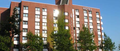A hotel with a brick facade, multiple windows, and a sign indicating it is a hotel.