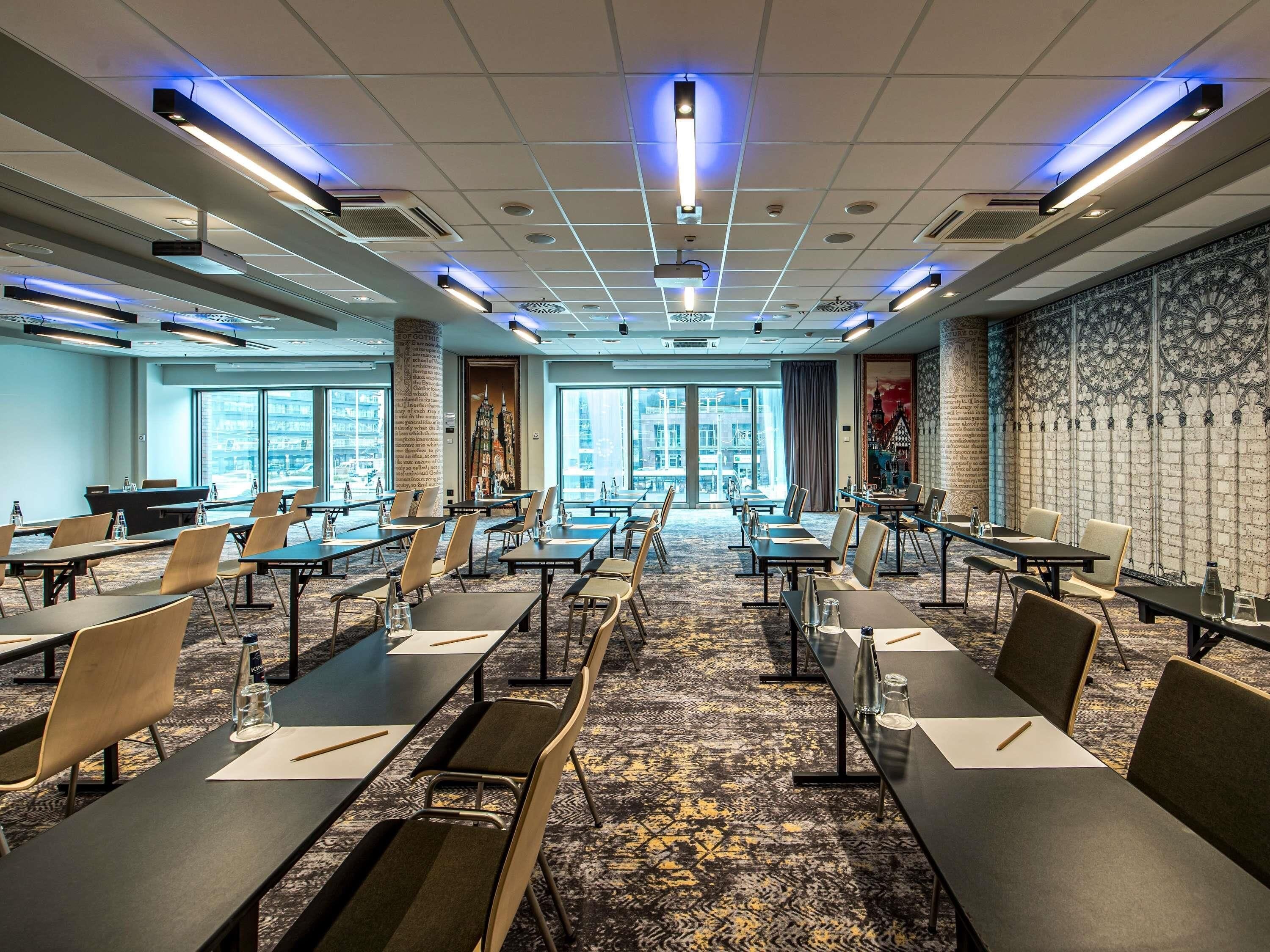 A conference room with tables, chairs, and a carpeted floor.