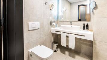 Une salle de bain moderne avec des toilettes, un lavabo et un miroir.