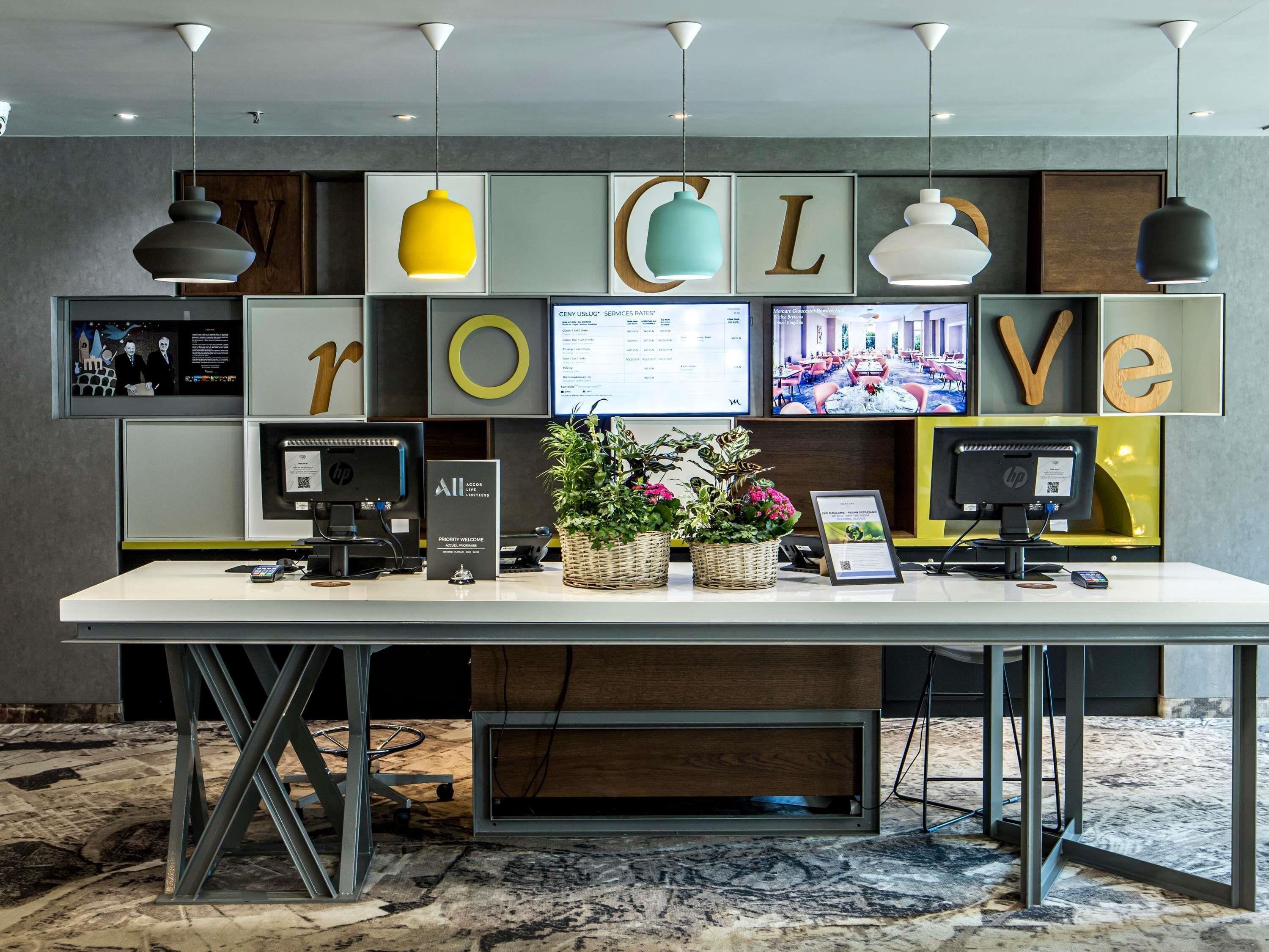 A reception desk with a white counter, multiple monitors, and a 'LOVE' sign above.