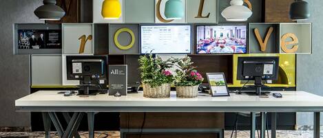 A reception desk with a white counter, multiple monitors, and a 'LOVE' sign above.