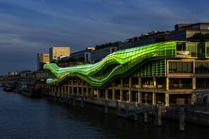 Un bâtiment situé au bord de l’eau, doté d’un toit vert remarquable et de plusieurs étages.