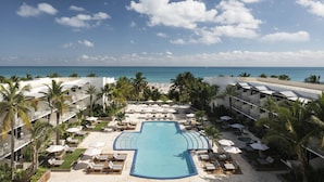 A resort with a central pool, beachside lounge areas, and a view of the ocean. - The Ritz-Carlton, South Beach (Miami Beach)