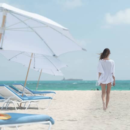 On the beach, white sand, beach cabanas, sun loungers