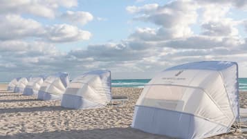 En la playa, arena blanca, camas de playa, sillas reclinables de playa