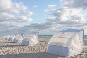 On the beach, white sand, beach cabanas, sun loungers
