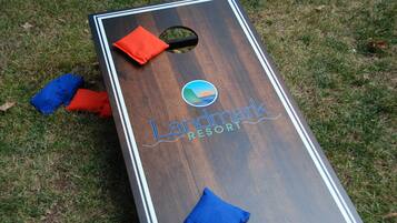 Ein hölzernes Brettspiel mit dem Schriftzug "Landmark Resort" und einem Logo, platziert auf Gras.