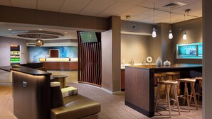 A modern hotel lobby with a reception desk, seating area, and bar. - Springhill Suites By Marriott Chicago Lincolnshire (Lincolnshire)
