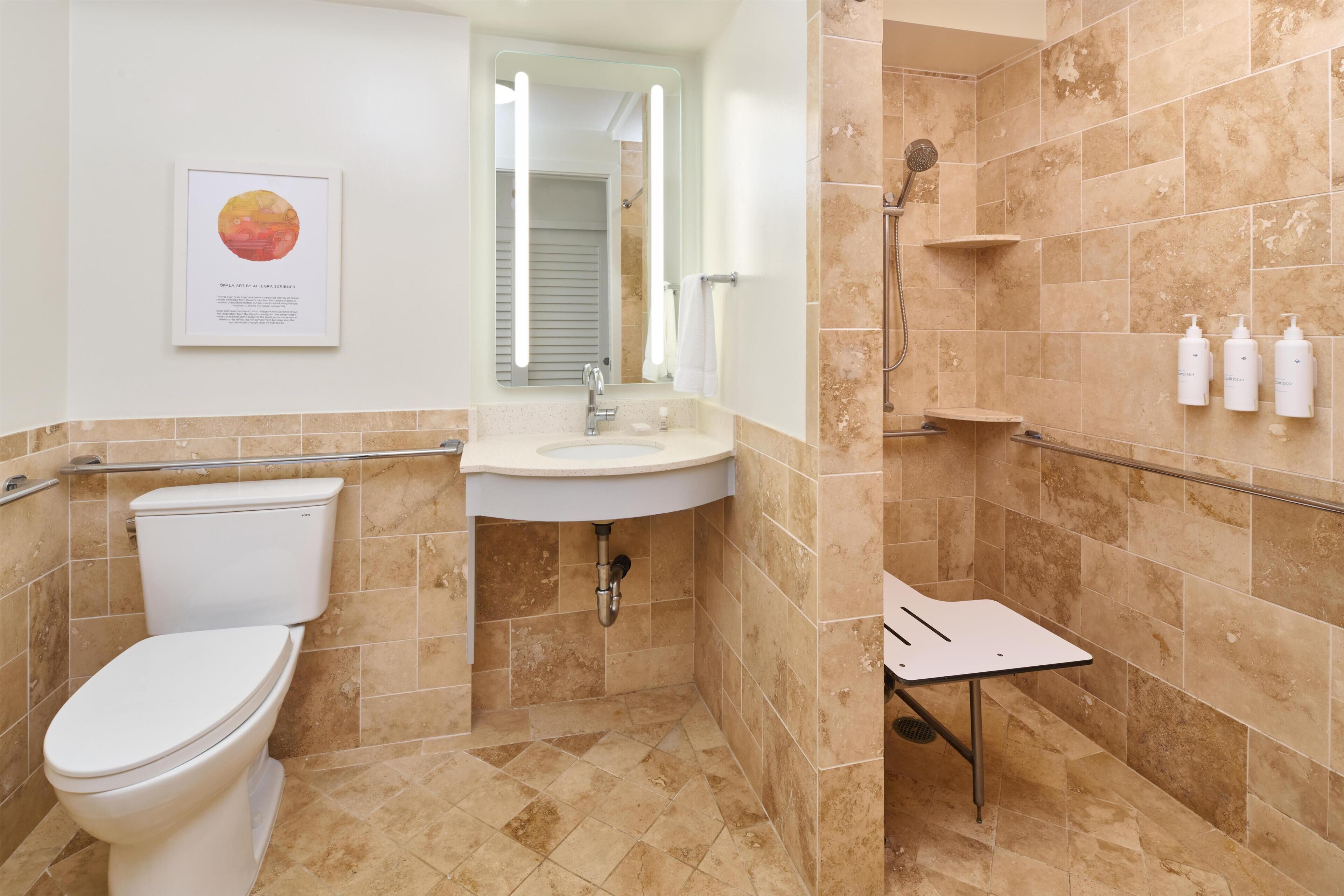 A bathroom with a toilet, sink, shower, and handrails.