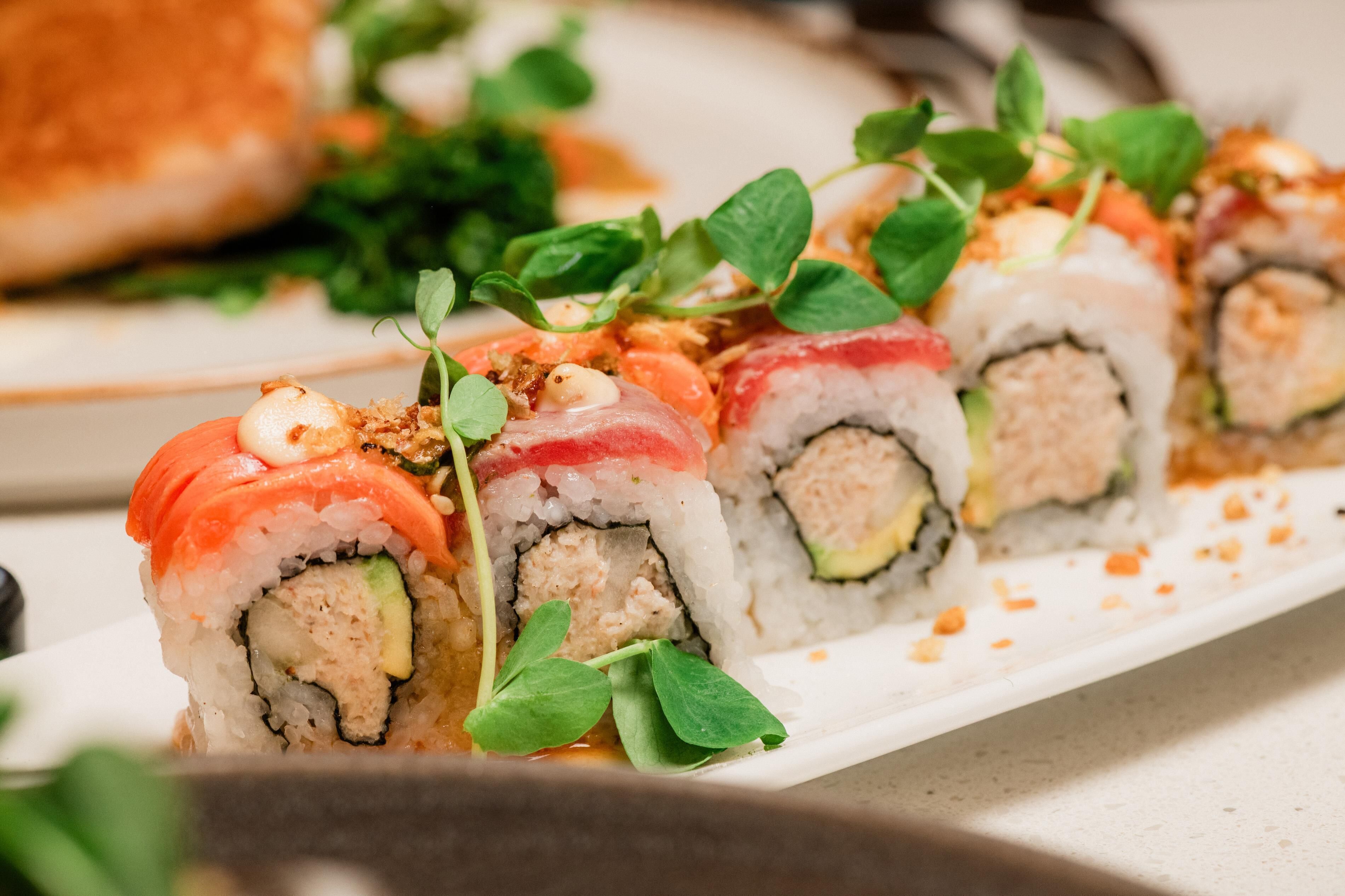 Um prato de sushi com diversos acompanhamentos e guarnições.