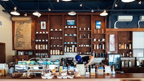 A coffee shop interior with wooden shelves, a menu board, and a coffee machine.