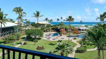 Un resort con piscina, palmeras y vista al océano.