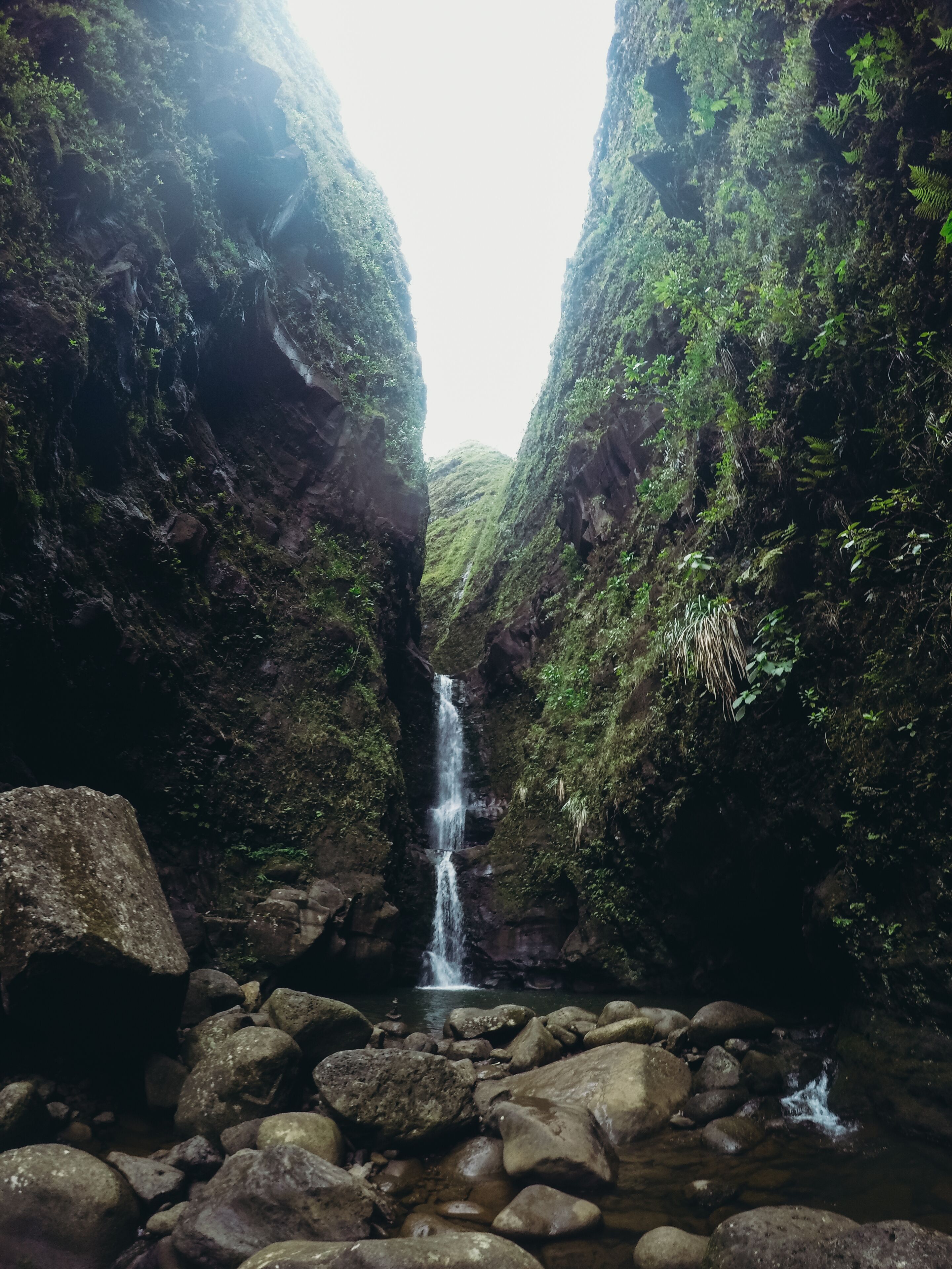 Un congost estret amb una cascada i un terreny rocos.