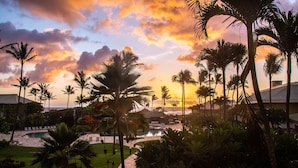 A resort with a pool, palm trees, and a sunset view.