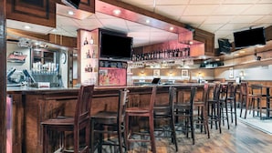 Un bar avec des meubles en bois, un comptoir avec une caisse enregistreuse et des étagères remplies de bouteilles.
