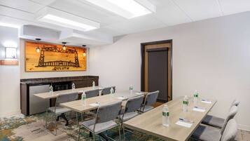 A conference room with a long table, multiple chairs, and a fireplace.