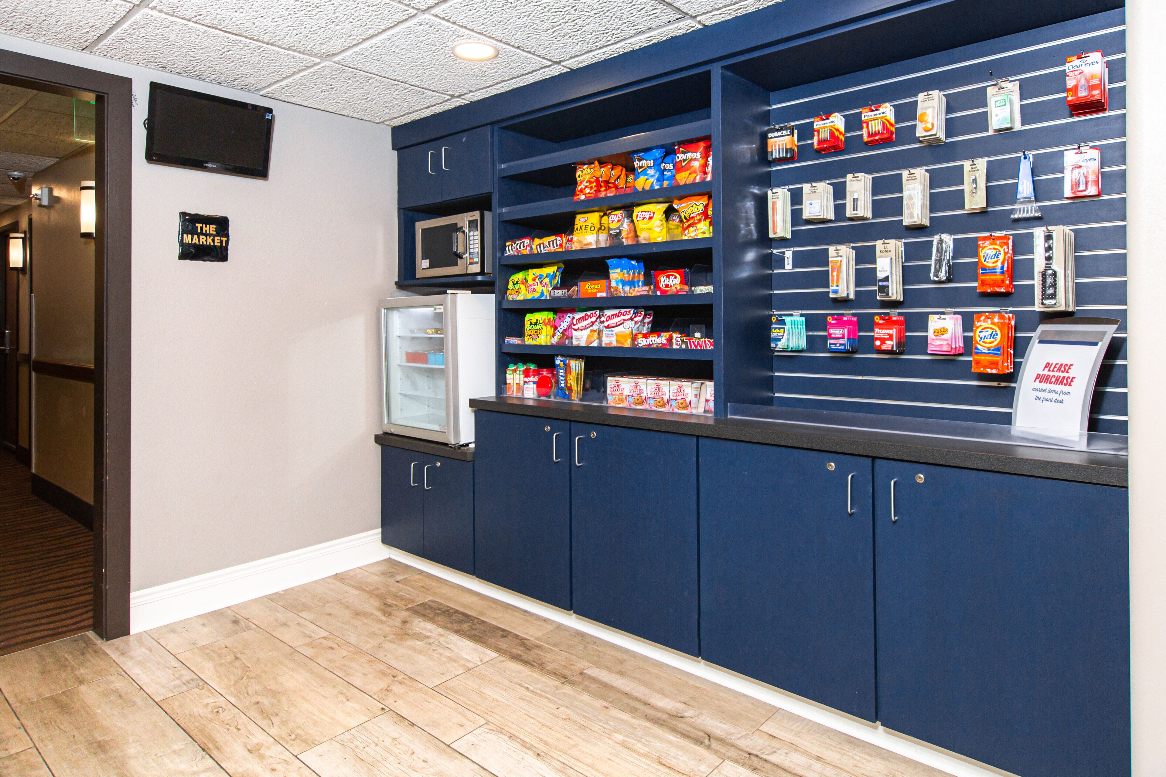 A snack display area with various packaged snacks and a microwave.