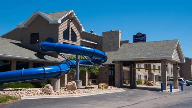 A hotel with a blue water slide in front.