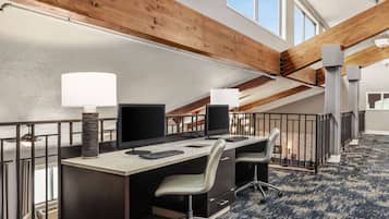 A conference room with two desks, chairs, and a large window.