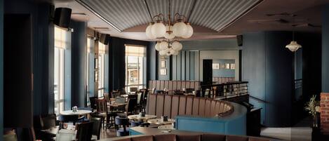 A modern restaurant interior with high ceilings, large windows, and a curved seating area.