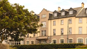 A multi-story hotel with a symmetrical facade, large windows, and a well-maintained lawn.