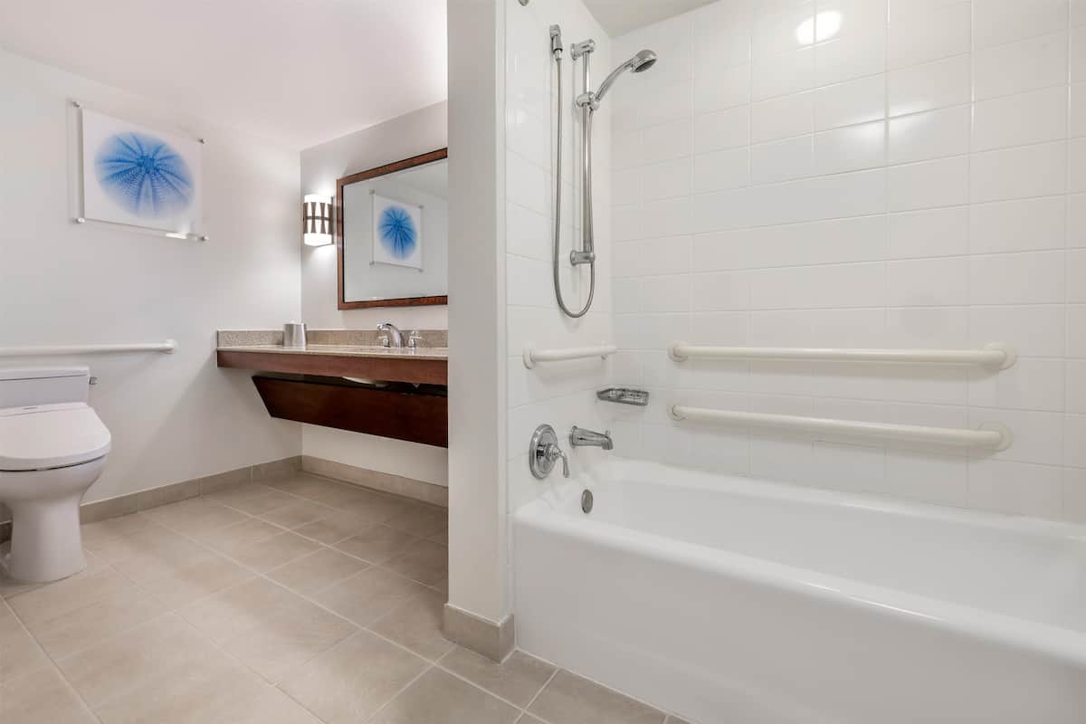 A modern bathroom with a toilet, sink, and bathtub.