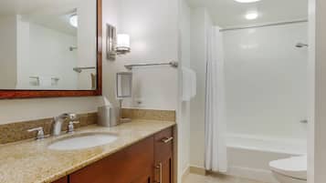 A bathroom with a sink, mirror, towel rack, and shower.