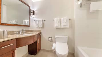 Et badeværelse med håndvask, spejl, toilet og badekar.