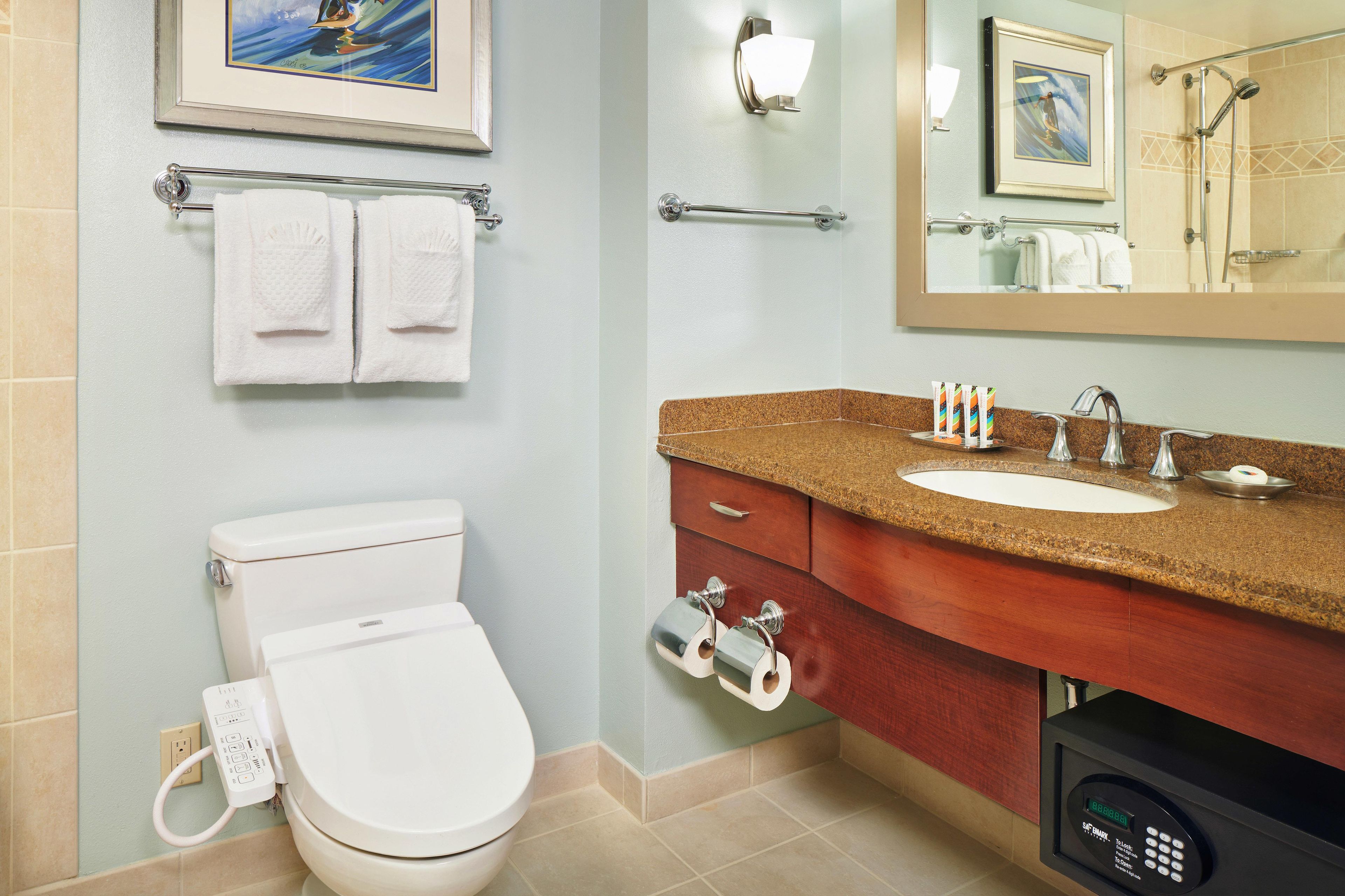 Une salle de bain avec des toilettes, un lavabo et un miroir.