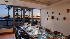 A dining area with a view of the beach, large windows, and decorative wall art. - Hilton Grand Vacations Club at Hilton Hawaiian Village (Honolulu)