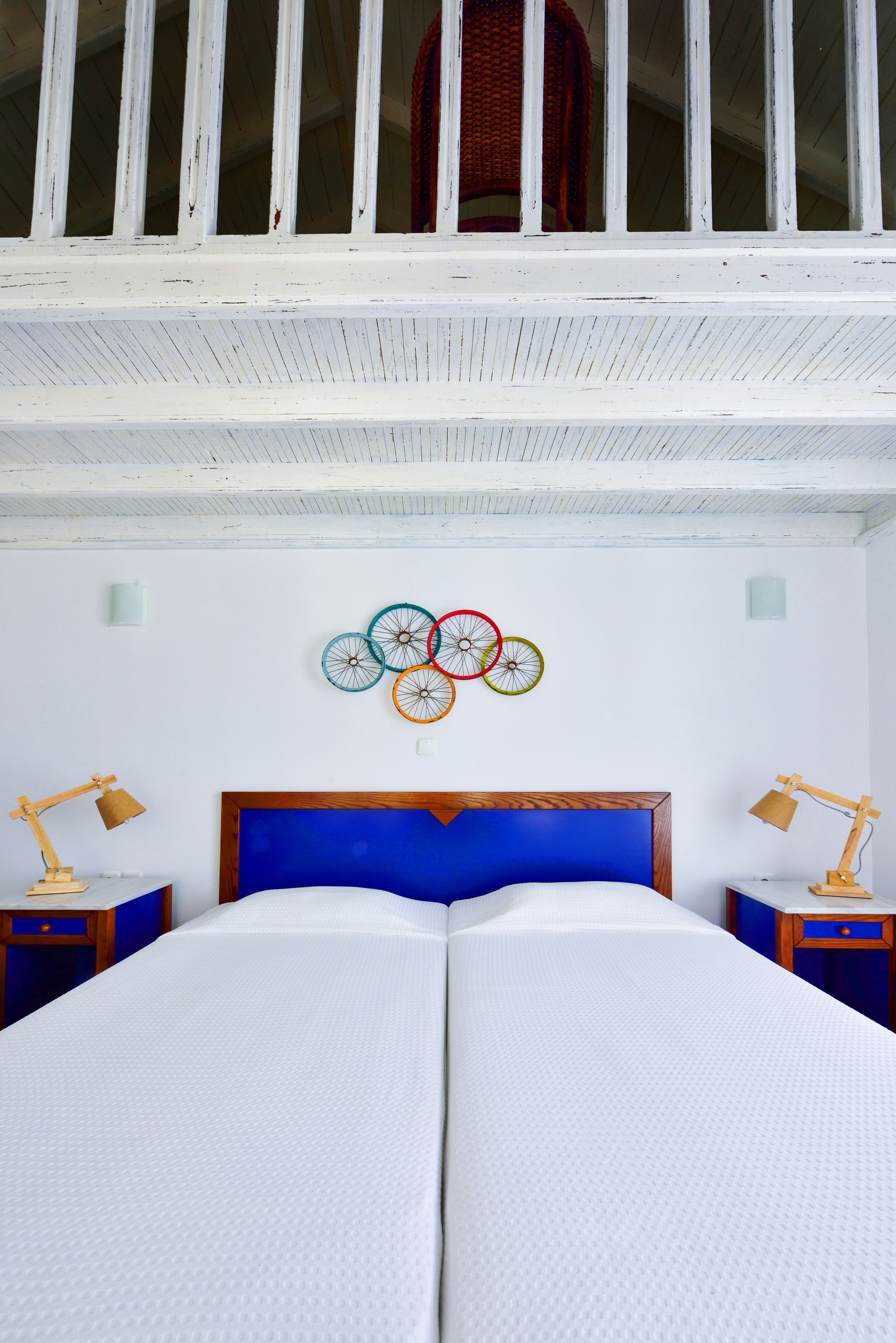 Un dormitorio con cama doble, cabecero de madera y una decoración de rueda de bicicleta en la pared.