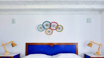A bedroom with a double bed, wooden headboard, and a wall-mounted bicycle wheel decoration.