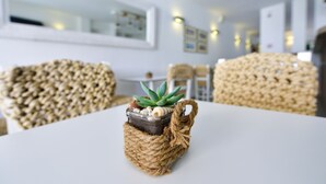 A dining table with a woven basket containing a succulent plant. - Kalidon Beach Hotel (Samos)