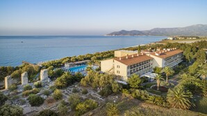 A coastal hotel with a swimming pool, surrounded by greenery and overlooking the sea. - Doryssa Seaside Resort (Samos)