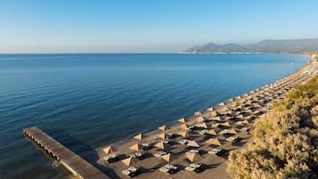 På stranden, solsenger, parasoller og strandhåndklær