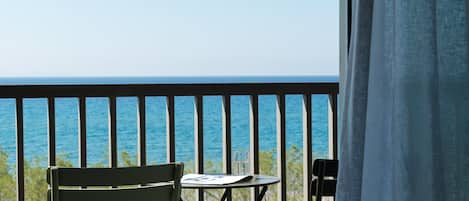Varanda com vista para o oceano, uma mesa e duas cadeiras.