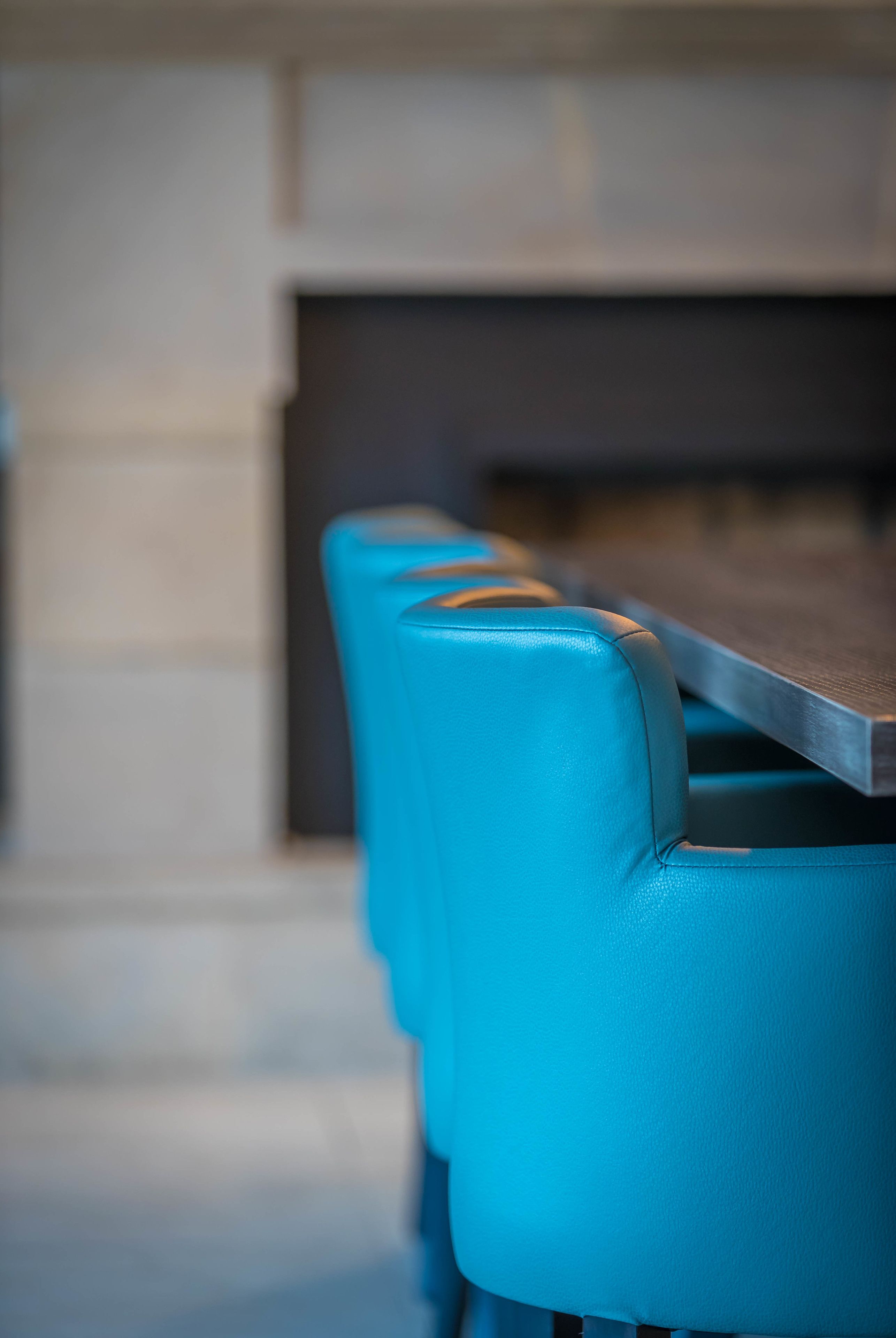 A row of blue chairs with a wooden table in a modern interior setting.