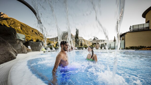 A hot tub area with water jets, lounge chairs, and a mountainous backdrop. - Engadiner Boutique-Hotel GuardaVal (Scuol)