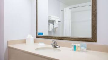 A bathroom with a sink, mirror, and towel rack.